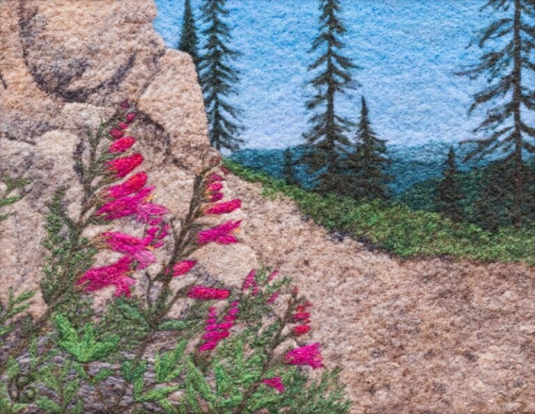 Colorful mountain landscape with pink wildflowers.