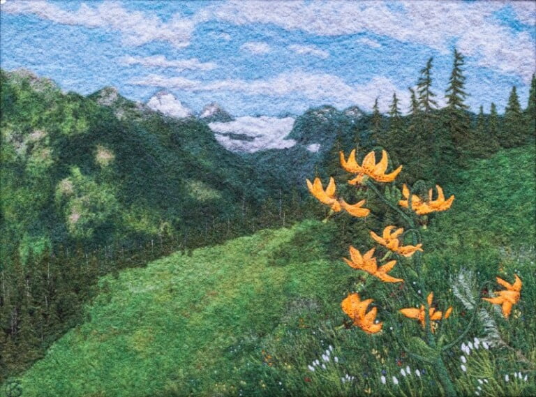 Mountain landscape with orange wildflowers and evergreen trees.